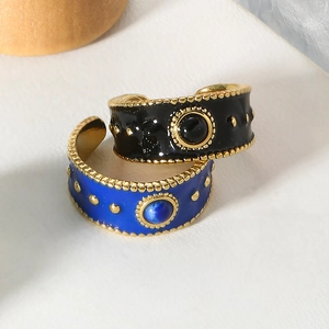 Macro shot of vintage style black and blue enamel open rings with gold plating and beads