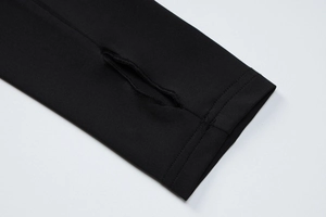 Dettaglio ravvicinato delle maniche lunghe con foro per il pollice su un abito in maglia nera
