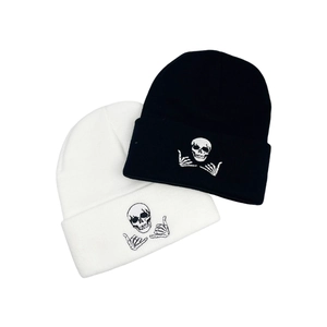 Set of black and white knitted beanies with skull and skeleton hand embroidery