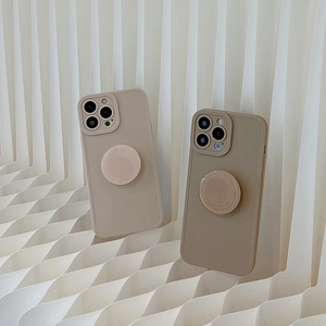 Detail view of beige and khaki matte iPhone cases with matching round grip stands