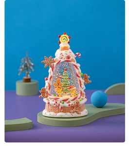 Macro view of gingerbread tree snow globe with built-in LED lighting and festive details