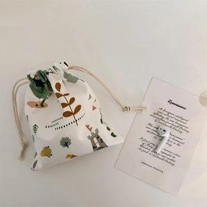 Detail of canvas drawstring pouch featuring forest patterns and side cord closure