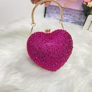 Detail of rose red rhinestone heart-shaped evening bag with gold ring handle and hardware