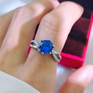 Detailed macro view of a 2-carat blue sapphire ring with twisted band and pave diamonds