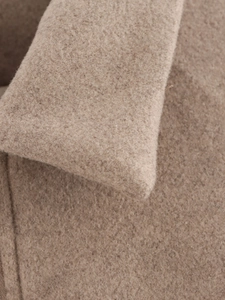 Détail du tissu en laine et des coutures sur la veste camel à fermeture éclair