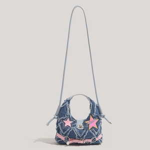 Y2K denim crossbody bag featuring pink star patches and distressed frayed edges detail