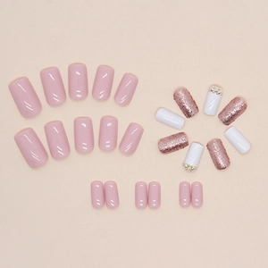 Pink and white square press-on nails with sparkling diamond accents and rose gold glitter