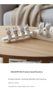 Detalle de seis figuras de gatos de madera con cascabeles dorados en taburetes y libros