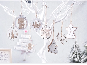 Close-up of laser-cut wooden Christmas ornaments with snowflakes and reindeer hanging on branches