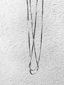 Dettaglio della collana a catena serpente argento minimalista con trama in metallo pregiato