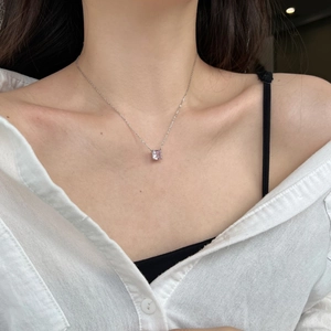 Close-up of S925 silver necklace with square pink zircon pendant worn on the neck