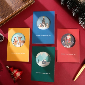 Flat lay of four colorful 3D Christmas cards with festive decor on red background