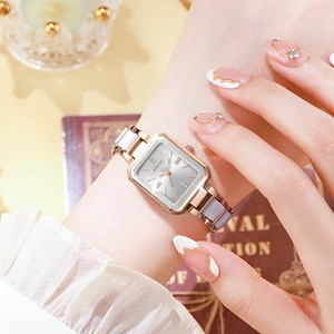 Detail of elegant square rose gold watch with white accents on female wrist