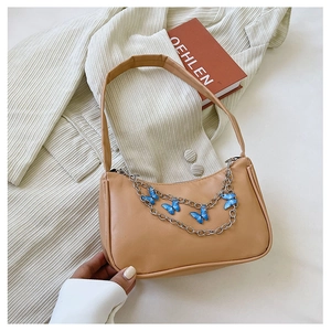 Detail of khaki shoulder bag with blue butterfly charms on a silver metal chain