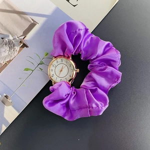 Close-up of stylish women watch with purple satin ribbon strap and gold bezel