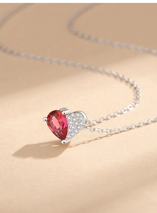Macro shot of heart pendant with red ruby-style gem and white pave set cubic zirconia