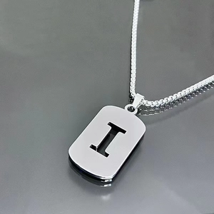 Macro view of silver stainless steel box chain and letter I rectangular pendant