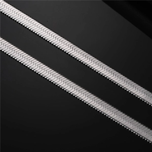Macro shot of two silver stainless steel snake bone chains with dense metallic texture