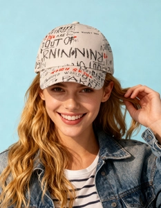 Close-up of beige cotton baseball cap with graffiti print and denim jacket details