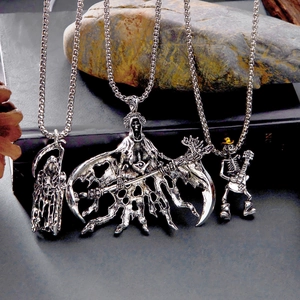 Vue détaillée de colliers gothiques argentés avec pendentifs faucheuse et crâne guitare