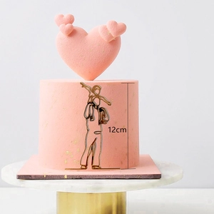 Close-up of a 12cm gold minimalist wire father and child cake topper on a pink cake