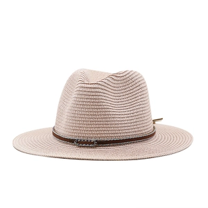 Close-up of woven straw fedora featuring a brown leather band and colorful metal buckle