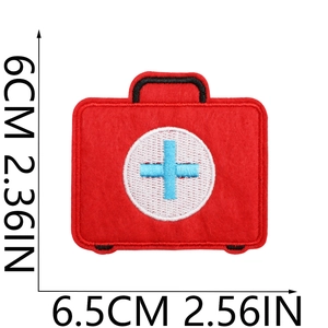Macro view of red first aid kit embroidery patch with size guides showing 6x6.5cm dimensions