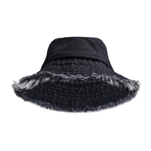 Detail of frayed edges and distressed texture on black denim bucket hat