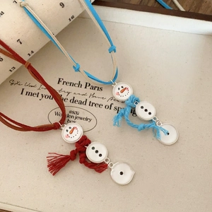 Detail of velvet rope necklaces with snowman pendants in red and blue festive designs