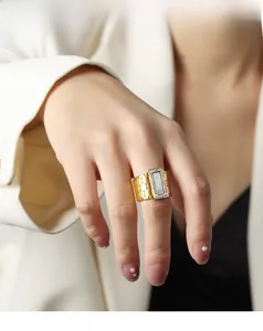 Detailed view of gold titanium ring with white shell inlay and honeycomb texture