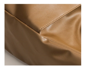 Close-up of the vintage brown leather texture and premium stitching on the shoulder bag