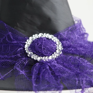 Close-up of Halloween witch hat with purple lace trim and sparkling rhinestone buckle