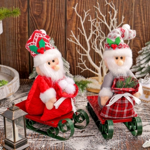 Two festive Santa Claus dolls on metal sleds with gift bags for Christmas decoration