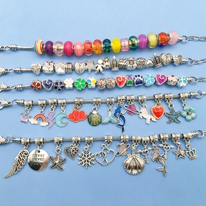 Detail of DIY charm bracelets featuring colorful glass beads and enamel pendants
