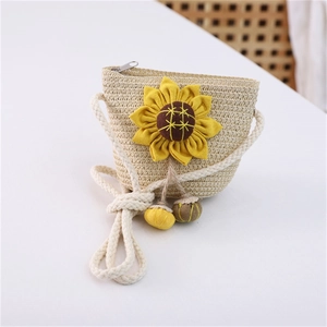 Detail of summer straw crossbody bag featuring yellow sunflower applique and rope strap