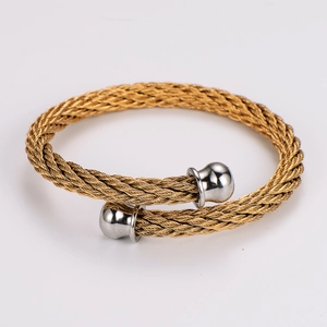 Detail of twisted steel wire bracelet with gold band and silver sphere ends