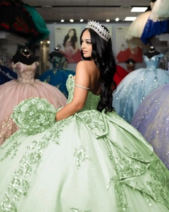 Detail of mint green quinceanera dress featuring sequined lace and floral embroidery