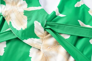 Macro detail of floral swimsuit featuring reinforced double stitching and cross straps