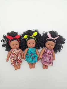 Detailed view of three African baby dolls in various floral outfits with headbands
