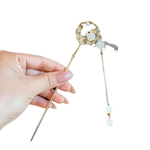 Golden hair stick with rabbit and magnolia flower pendant and tassel held by hand