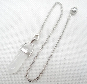 Macro shot of white crystal hexagonal prism pendant with a silver filigree ball chain