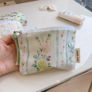 Detail showing simple wish floral cotton coin purse with zipper and side label