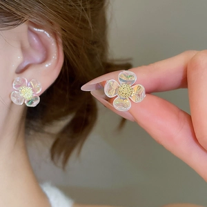 Detail of flower stud earrings with iridescent petals and gold frosted centers