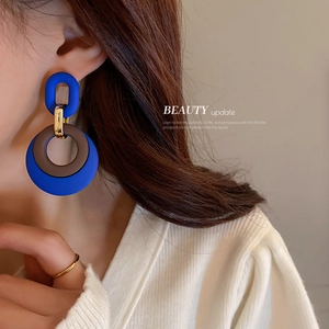 Klein blue and brown geometric link earrings shown on model with matte finish details