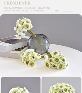 Close-up of realistic white ranunculus artificial bouquet in a gray glass vase
