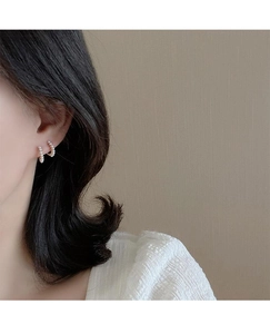 Close-up of minimalist tiny pearl hoop earrings worn elegantly on the ear