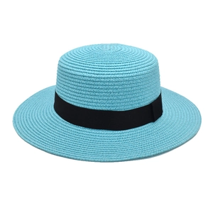 Close-up of sky blue boater straw hat featuring a wide brim and decorative black ribbon