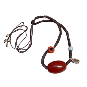 Ethnic wax cord necklace with red agate, rhodochrosite and jade beads on white background