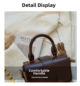 Detail of dark brown leather handbag with cylindrical handle and cute bunny charm accessory
