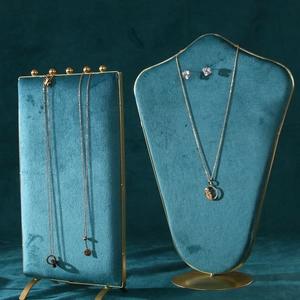 Detail of luxury green velvet necklace stand and jewelry display holder with gold metal frame